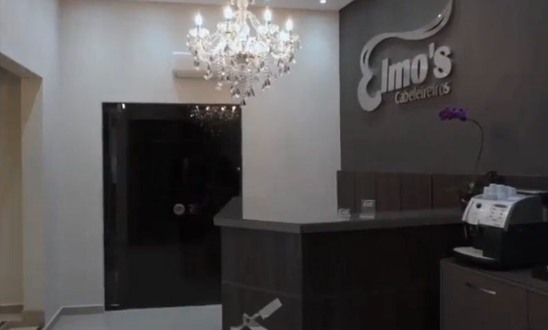 Recepção do Elmo's Cabeleireiros com lustre de cristal e letreiro em prata