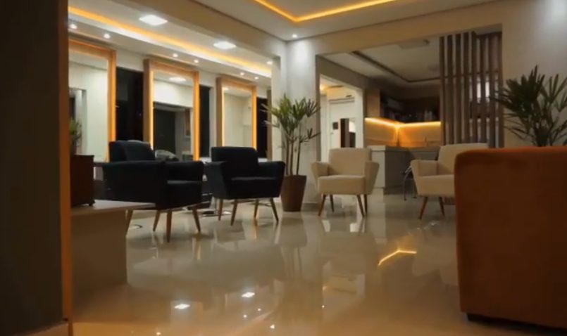 Lounge de espera do salão com poltronas e iluminação quente